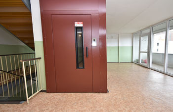 Poslední nadzemní podlaží, výtah do 6. patra, poté pár schodů k bytu.  - Prodej bytu 4+1 v osobním vlastnictví 72 m², Praha 8 - Karlín