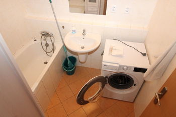 koupelna - nová pračka - pohled z chodby  - Pronájem bytu 1+kk v osobním vlastnictví 35 m², Praha 10 - Hostivař