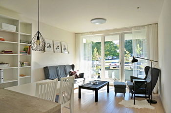 Obývací pokoj s kuchyňským koutem (25,6 m2) a balkonem (5,6 m2) - Prodej bytu 3+kk v osobním vlastnictví 62 m², Brno 