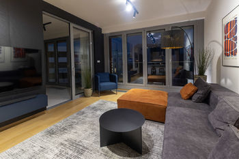 Obývací pokoj ve večerním nasvícení - Prodej bytu 2+kk v osobním vlastnictví 63 m², Praha 8 - Libeň