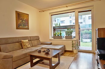  Obývací pokoj 24 m2 s kuchyňským koutem a vstupem na terasu a zahrádku 43 m2 - Prodej bytu 2+kk v osobním vlastnictví 61 m², Moravany