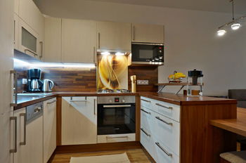 Kuchyňský kout s vestavnými spotřebiči Bosch - plynová varná deska, trouba, mikrovlnka, myčka, digestoř, lednice s mrazákem - Prodej bytu 2+kk v osobním vlastnictví 61 m², Moravany