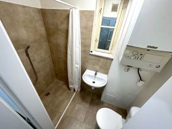 Koupelna - Prodej bytu 1+kk v osobním vlastnictví 23 m², Praha 10 - Vršovice