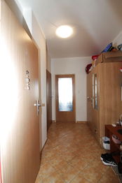 chodba, pohled od vstupních dveří - Prodej bytu 1+kk v osobním vlastnictví 39 m², Praha 9 - Vysočany