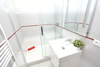 Koupelna se sprchovým koutem, umyvadlem se skříňkou a zrcadlem.  - Pronájem bytu 2+kk v osobním vlastnictví 47 m², Neratovice