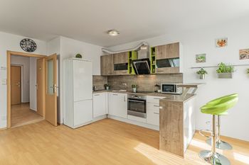 Obývací pokoj s kuchyňským koutem a vnitřní chodba bytu - Prodej bytu 2+kk v osobním vlastnictví 50 m², Jinočany