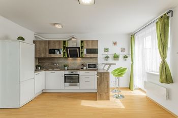 Obývací pokoj s kuchyňským koutem, barem a vstupem na balkon - Prodej bytu 2+kk v osobním vlastnictví 50 m², Jinočany