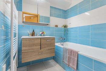 Koupelna s vanou, umyvadlem a prostorem pro pračku - Prodej bytu 2+kk v osobním vlastnictví 50 m², Jinočany