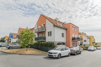 Pohled na dům z ulice a přilehlá parkovací stání - Prodej bytu 2+kk v osobním vlastnictví 50 m², Jinočany
