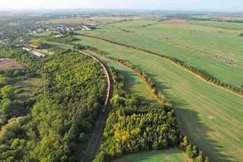 letecký snímek s železniční tratí - Prodej pozemku 6670 m², Praha 10 - Kolovraty