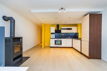 Obývací pokoj s kuchyňským koutem a krbovými kamny - Prodej bytu 3+kk v osobním vlastnictví 72 m², Týnec nad Sázavou 