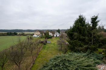 Pohled na východní (zadní část) pozemku - Prodej pozemku 1253 m², Bělušice