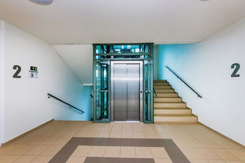 Prosklený interiér hlavní chodby domu - Prodej bytu 2+kk v osobním vlastnictví 57 m², Praha 9 - Vysočany