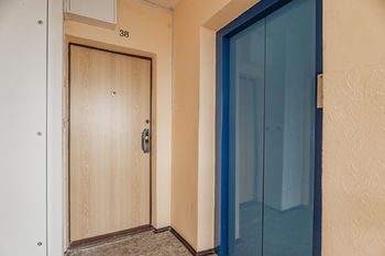Vstupní dveře a výtah vedle jednotky - Prodej bytu 2+kk v osobním vlastnictví 45 m², Praha 8 - Kobylisy