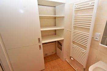 Koupelna s vanou, umyvadlem a vestavnou skříní s přívodem na pračku.   - Pronájem bytu 3+1 v osobním vlastnictví 87 m², Praha 2 - Vinohrady