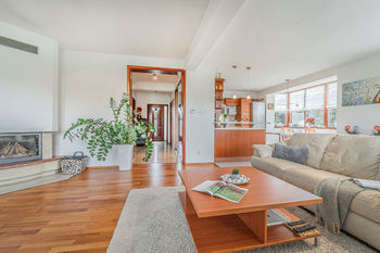 Obývací pokoj s krbem a kuchyní - Prodej domu 190 m², Buštěhrad