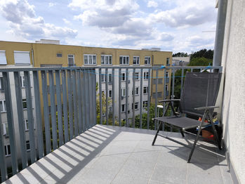 Obývací pokoj s kuchyňský koutem, jídelním koutem a vstupem na balkón.  - Prodej bytu 3+kk v osobním vlastnictví 96 m², Praha 5 - Motol