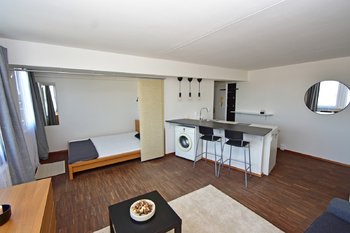 Obývací pokoj kuchyňským koutem a ložnicí. - Pronájem bytu 1+kk v osobním vlastnictví 35 m², Praha 8 - Karlín