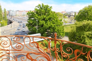 Dva balkony – První balkon nabízí výhled na ikonický Tančící dům a klidnou hladinu Vltavy – ideální pro ranní kávu s inspirací. Druhý balkon směřuje do tichého vnitrobloku, kde se večerní sklenka vína - Prodej bytu 3+kk v osobním vlastnictví 125 m², Praha 5 - Smíchov