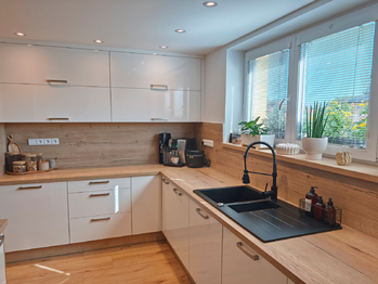 Kuchyňský kout, jídelní kout a obývací pokoj se vstupem na terasu a zahradu.  - Prodej domu 128 m², Nová Ves