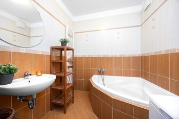 Prostorná koupelna s rohovou vanou - Prodej bytu 2+kk v osobním vlastnictví 67 m², Praha 5 - Zličín