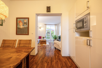 jídelní stůl s průhledem do obývacího pokoje - Prodej bytu 2+kk v osobním vlastnictví 86 m², Praha 10 - Dolní Měcholupy