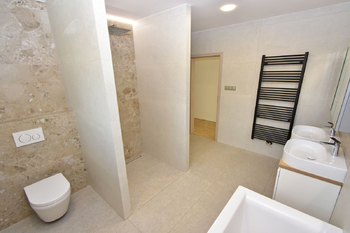 Koupelna s vanou, sprchovým koutem, toaletou a umyvadly s toaletní skříňkou. - Pronájem domu 147 m², Kostelec nad Labem