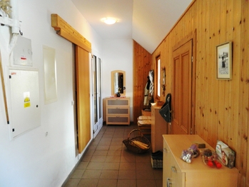 Hala. Vlevo jsou šoupací dveře, kryjící schodiště do podkroví.  - Prodej domu 396 m², Přehořov