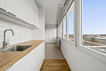 Kuchyňský kout s moderní kuchyňskou linkou se zabudovanými spotřebiči: elektrická trouba s mikrovlnnou funkcí, indukční varná deska, lednice s mrazákem a myčka nádobí.  - Prodej bytu 1+kk v osobním vlastnictví 28 m², Hradec Králové