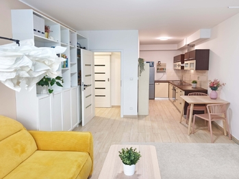 Obývací pokoj se vstupem na terasu a zahradu, jídelní a kuchyňský kout.  - Prodej bytu 2+kk v osobním vlastnictví 52 m², Praha 9 - Hostavice 