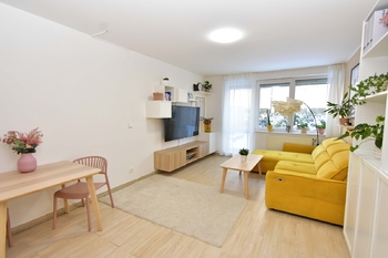 Obývací pokoj se vstupem na terasu a zahradu, jídelní a kuchyňský kout.  - Prodej bytu 2+kk v osobním vlastnictví 52 m², Praha 9 - Hostavice