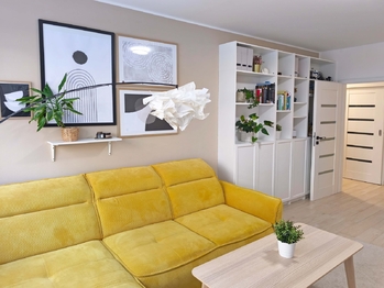 Obývací pokoj se vstupem na terasu a zahradu, jídelní a kuchyňský kout.  - Prodej bytu 2+kk v osobním vlastnictví 52 m², Praha 9 - Hostavice