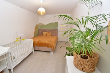 Prostorná samostatná ložnice s okny do zahrady.  - Prodej bytu 2+kk v osobním vlastnictví 52 m², Praha 9 - Hostavice