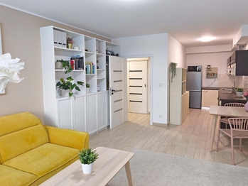 Obývací pokoj se vstupem na terasu a zahradu, jídelní a kuchyňský kout.  - Prodej bytu 2+kk v osobním vlastnictví 52 m², Praha 9 - Hostavice