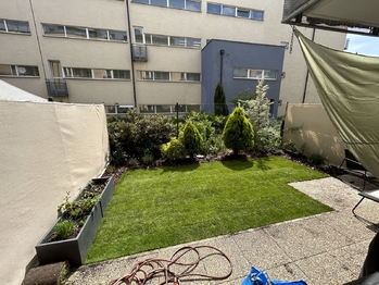 Zahrada a terasa u bytu.  - Prodej bytu 2+kk v osobním vlastnictví 52 m², Praha 9 - Hostavice