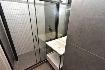 Koupelna se sprchovým koutem, umyvadlem, zrcadlem a toaletou.  - Pronájem bytu 2+kk v osobním vlastnictví 53 m², Čelákovice