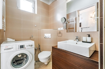 Koupelna je dále vybavena pračkou a toaletu - Pronájem bytu 1+kk v osobním vlastnictví 28 m², Praha 6 - Břevnov