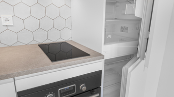 Detail varné desky, kombinované trouby a lednice s mrazákem - Pronájem bytu 1+kk v družstevním vlastnictví 27 m², Praha 9 - Libeň