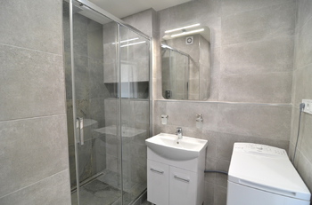 koupelna s pračkou, sprchovým koutem a umyvadlem s koupelnovou skříňkou - Pronájem bytu 2+kk v osobním vlastnictví 46 m², Praha 5 - Stodůlky