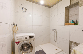 Koupelna je obložena velkoformátovými dlaždicemi imitující lesklý mramor a je zapotřebí její dokončení - Prodej domu 150 m², Chodouň