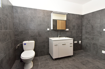 Koupelna se sprchovým koutem, umyvadlem se skříňkou, zrcadlem, toaletou a místem na pračku a sušičku.  - Pronájem bytu 2+kk v osobním vlastnictví 60 m², Kostelec nad Labem