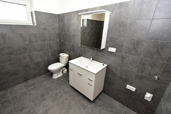 Koupelna se sprchovým koutem, umyvadlem se skříňkou, zrcadlem, toaletou a místem na pračku a sušičku.  - Pronájem bytu 2+kk v osobním vlastnictví 60 m², Kostelec nad Labem