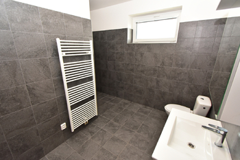 Koupelna se sprchovým koutem, umyvadlem se skříňkou, zrcadlem, toaletou a místem na pračku a sušičku.  - Pronájem bytu 2+kk v osobním vlastnictví 60 m², Kostelec nad Labem
