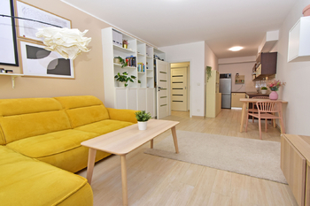 Obývací pokoj se vstupem na terasu a zahradu, jídelní a kuchyňský kout.  - Pronájem bytu 2+kk v osobním vlastnictví 52 m², Praha 9 - Hostavice