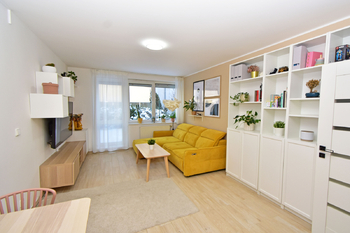 Obývací pokoj se vstupem na terasu a zahradu, jídelní a kuchyňský kout.  - Pronájem bytu 2+kk v osobním vlastnictví 52 m², Praha 9 - Hostavice