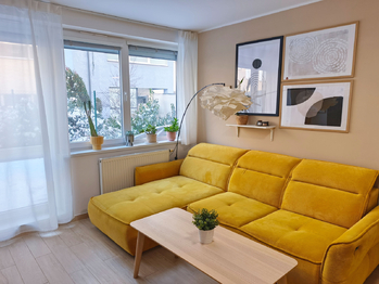 Obývací pokoj se vstupem na terasu a zahradu, jídelní a kuchyňský kout.  - Pronájem bytu 2+kk v osobním vlastnictví 52 m², Praha 9 - Hostavice