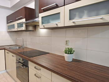 Obývací pokoj se vstupem na terasu a zahradu, jídelní a kuchyňský kout.  - Pronájem bytu 2+kk v osobním vlastnictví 52 m², Praha 9 - Hostavice