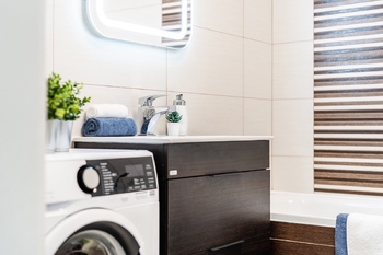 Koupelna s vanou, umyvadlem, toaletou a místem na pračku a sušičku. - Pronájem bytu 2+kk v osobním vlastnictví 52 m², Praha 9 - Hostavice