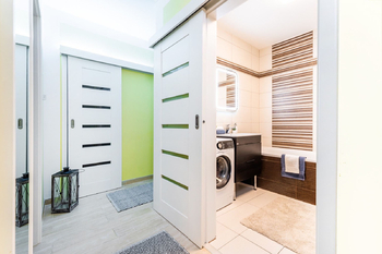 Vstupní chodba s 2x vestavěnou šatní skříní a samostatnou prostornou šatnou - před výmalbou na bílo. - Pronájem bytu 2+kk v osobním vlastnictví 52 m², Praha 9 - Hostavice