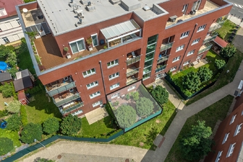 Pohled shora na okna a zahradu bytového domu - Prodej bytu 2+kk v osobním vlastnictví 63 m², Praha 4 - Modřany